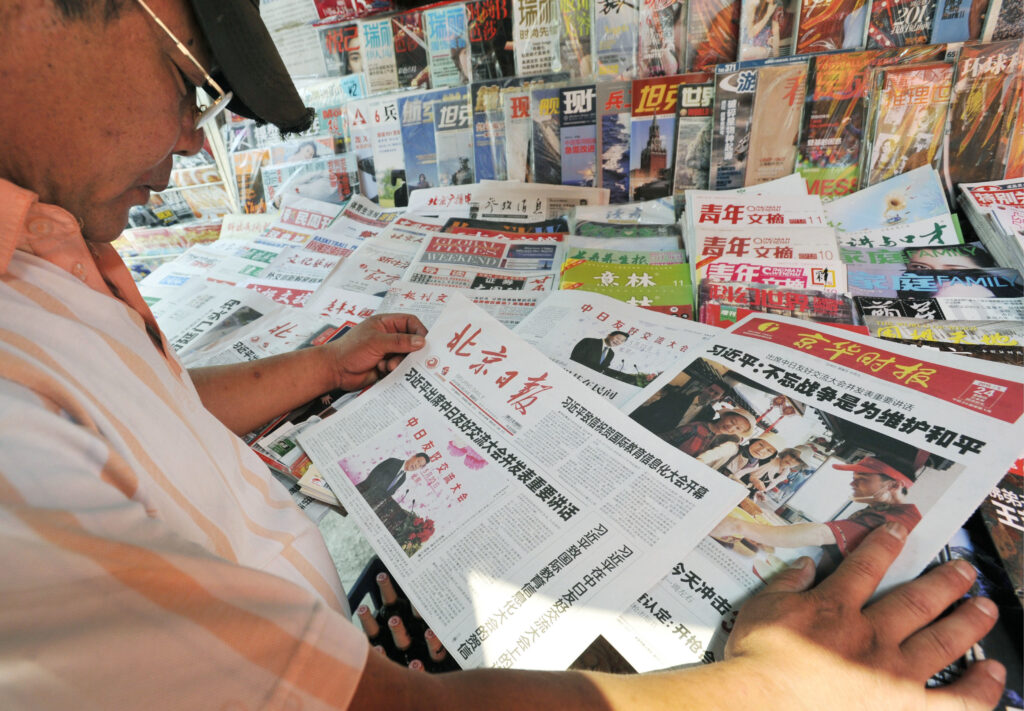 北京の街角で中国紙を読む男性。筆者はWiseSearch (慧科捜索)のデータベースを利用し、中国の各メディアの報道について比較分析をしている（写真：共同通信IMAGE LINK）