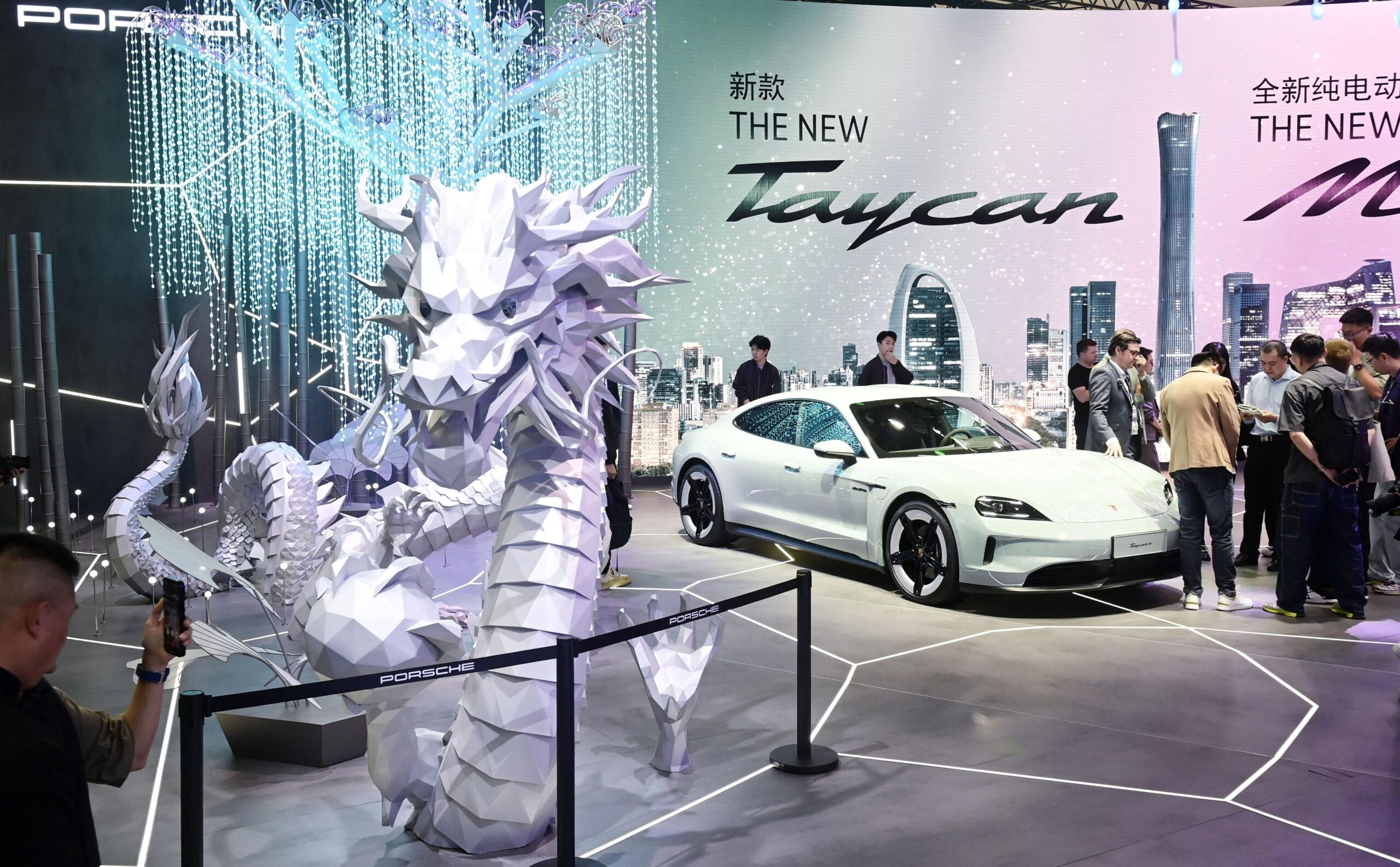 アメリカのバイデン政権は5月14日、中国製の電気自動車（EV）と太陽電池に対する制裁関税を引き上げると発表した。写真は「北京国際モーターショー」のブースに展示されたポルシェのEV ”Taycan”と龍。2024年4月25日（共同通信社）