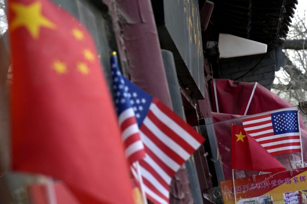 中国が開拓してきた非米国市場は、対米デカップリングによる損失を補って余りある力を備えている。写真は北京市内の土産屋に掲げられた中国と米国の国旗。2025年4月20日(共同通信社)
