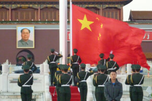 1949年以降の長期間にわたり、中央局のような組織の存在を通じて、中国の地方制度と国家戦略は高度な連動性を保ってきた、と著者は述べる。写真は北京の天安門に飾られている故毛沢東主席の肖像画と、国旗掲揚台の中国国旗。2012年10月26日（共同通信社）