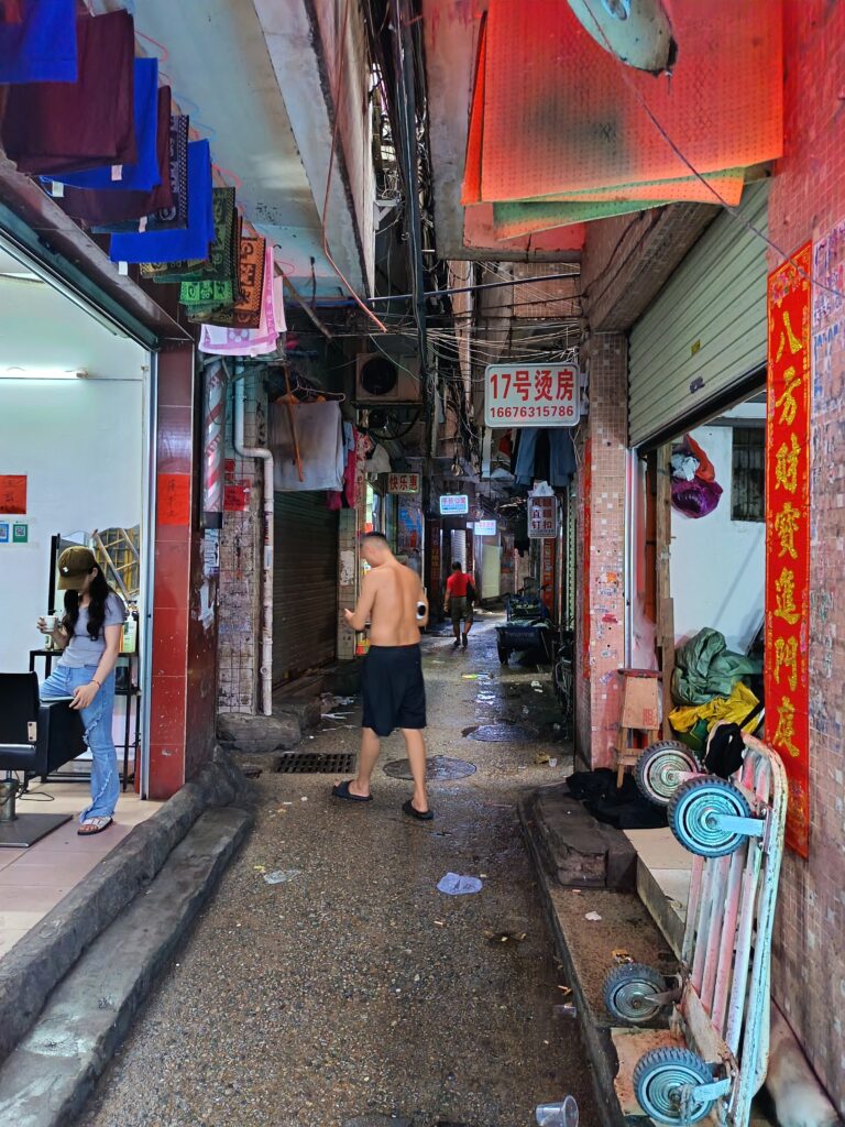 大塘村の様子。これでも立派な通路で、左は理髪店、右はアパレル関連の工場。