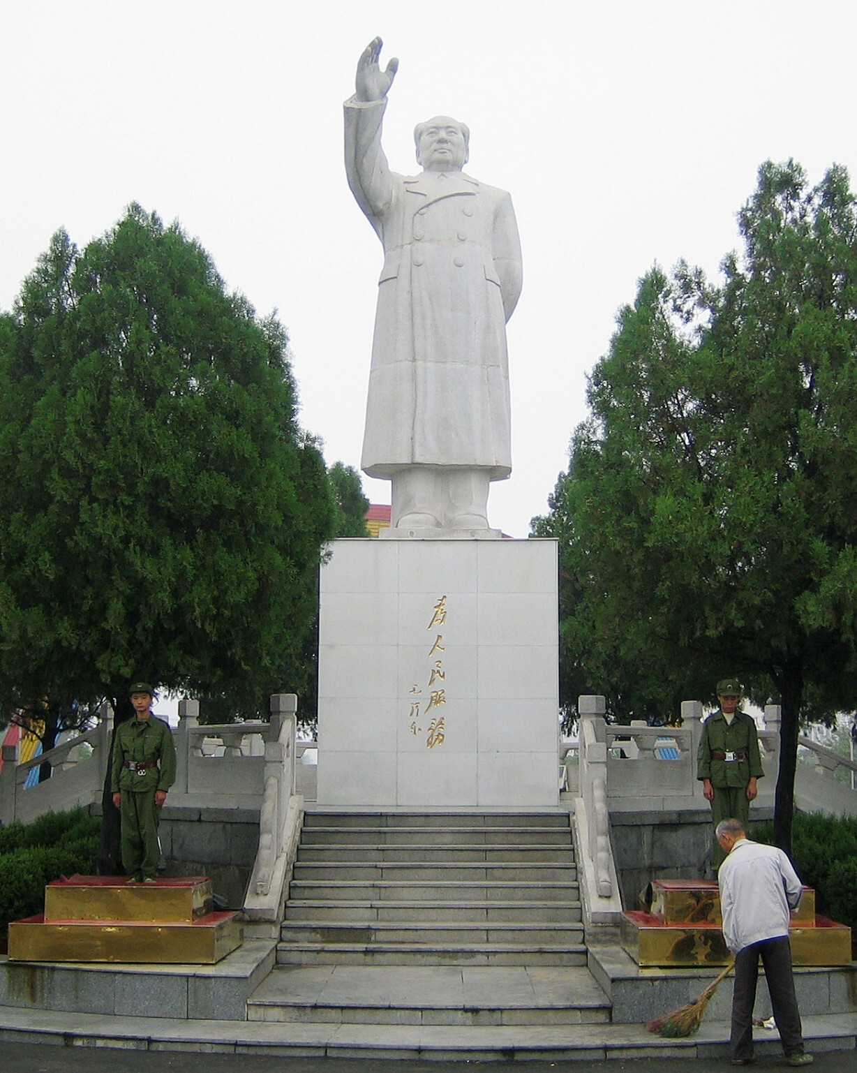 毛沢東が民兵に期待していた「階級闘争」は、宗族や集落間の抗争、あるいは略奪行為といった在地的な要素を内包した形で展開されていたとも言えよう。写真は、社会主義農村として知られる河南省・南街村の広場に建つ真っ白な毛沢東像と、その傍らで歩哨に立つ民兵。2006年8月30日（共同通信社）