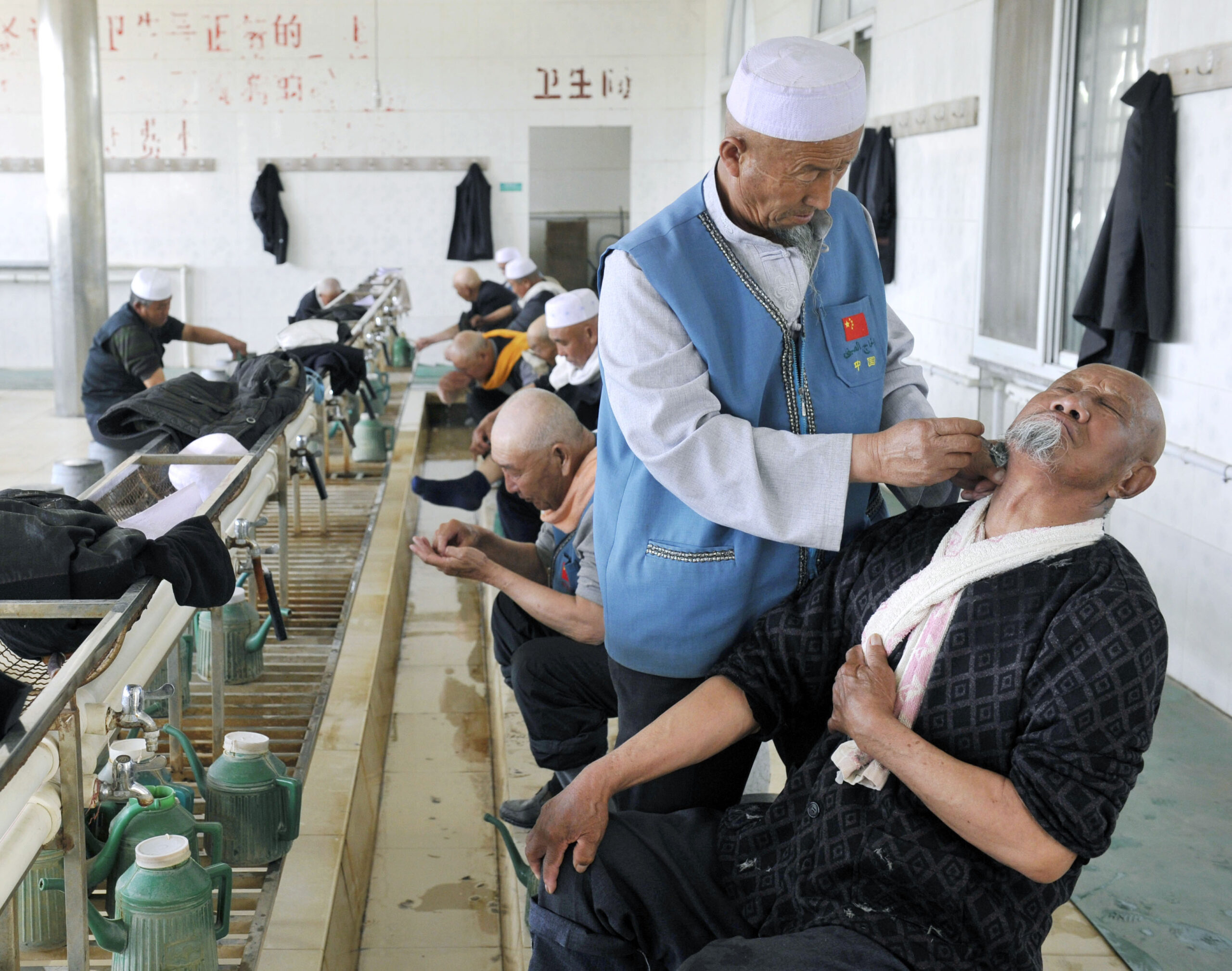 「中国」の宗教や民族に関心のある方、特にこの分野の研究を志す学生は、まず、固定された枠組みを疑い、あらゆる境界を往来する視座を大切にしてほしいと著者は語る。写真は寧夏回族自治区銀川市で、モスクへの礼拝を前に頭や顔をそってもらっている回族の老人。2014年4月29日（共同通信社）